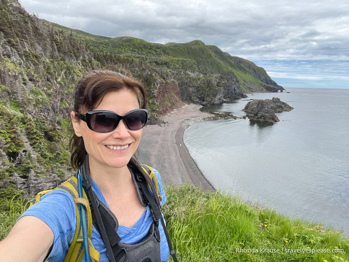 Taking a selfie with cliffs and a beach in the background.